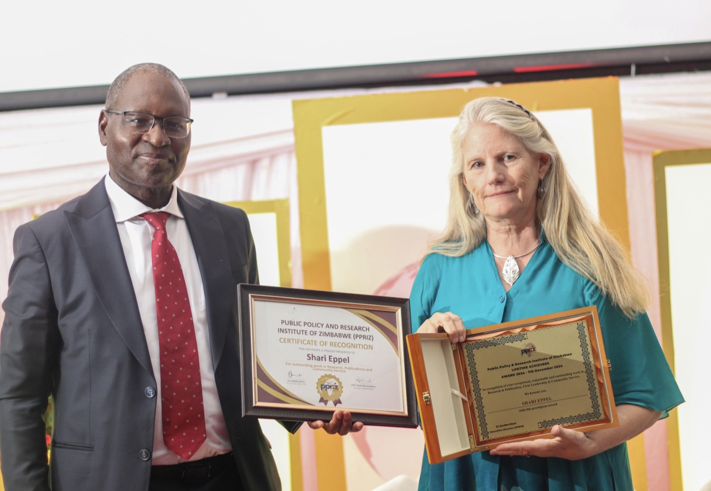 Shari Eppel receives a certificate of recognition from the Public Policy and Research Institute of Zimbabwe.